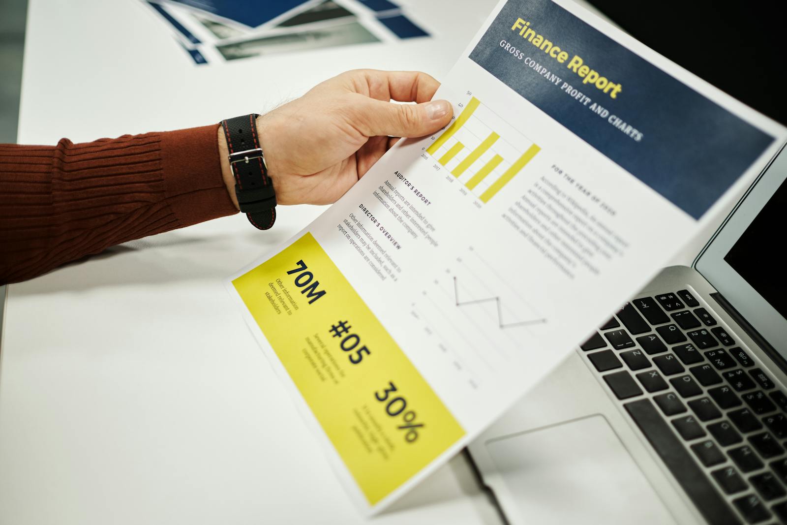 Person analyzing finance report with graphs at desk, ideal for business concepts.